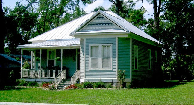 The James A. Herod House, a restored historic home with a covered front porch and standing-seam metal roof in downtown Abbeville, Louisiana